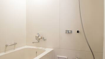 Un baño con bañera, ducha e inodoro.