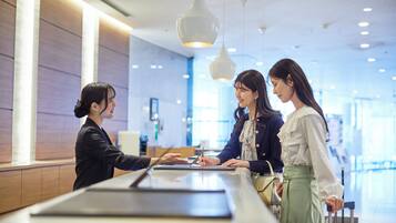 A reception area with a counter, modern pendant lighting, and a spacious interior.
