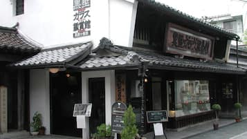A traditional Japanese building with a signboard and a small shop.