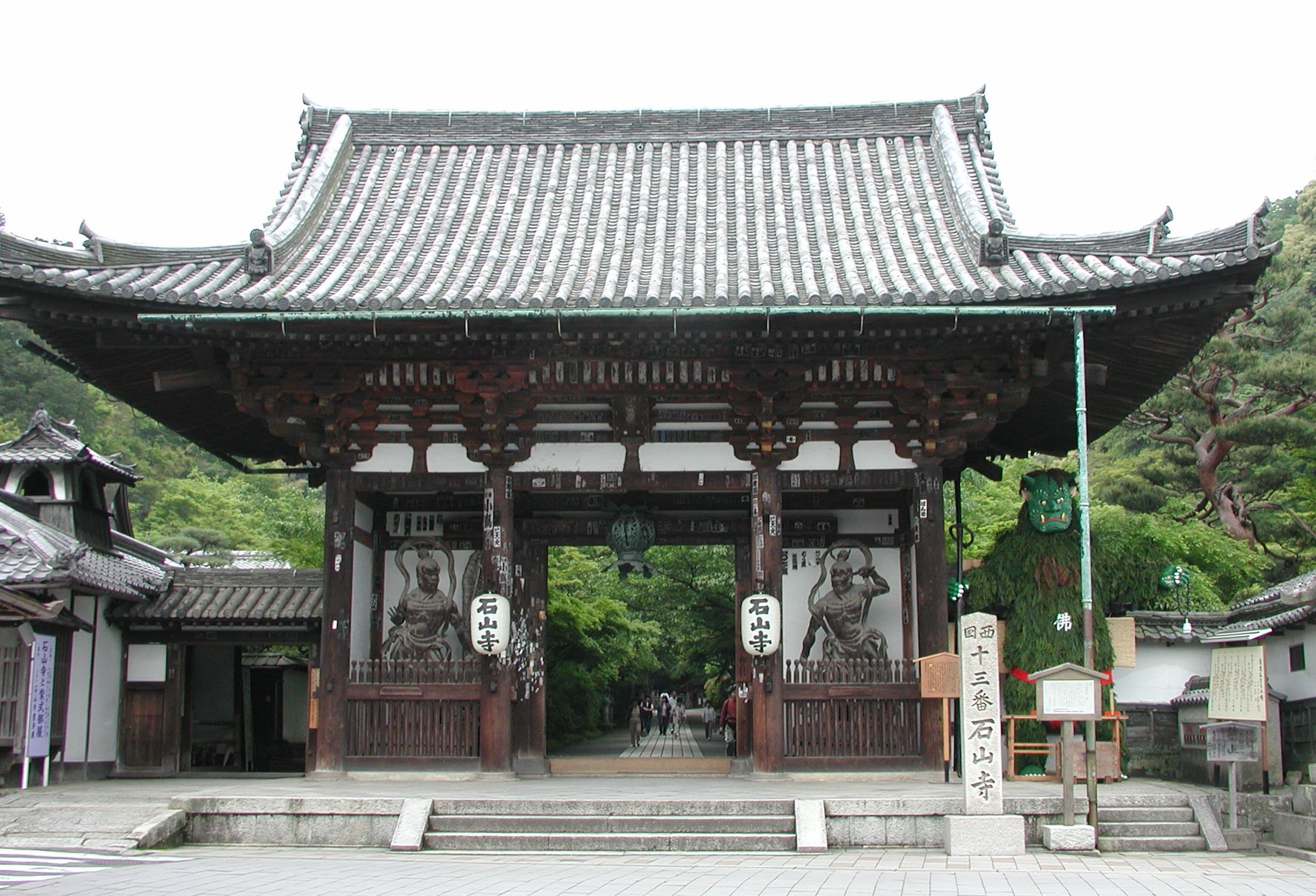 A traditional Japanese gate with intricate wooden carvings and a tiled roof.