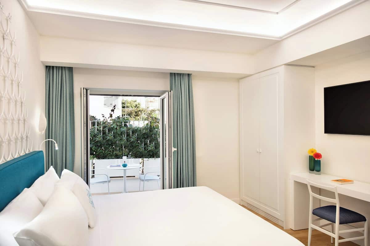 Une chambre d’hôtel avec un lit, un bureau et une vue sur l’extérieur.