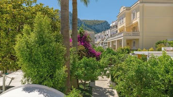 A courtyard with palm trees, a pathway, and buildings with balconies.