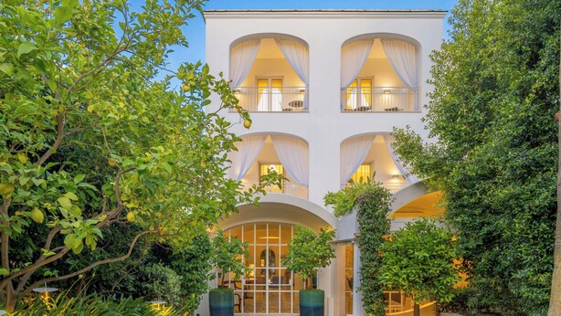 Un bâtiment à la façade symétrique, doté de grandes fenêtres et d’une entrée centrale avec une porte en verre.