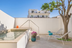 A rooftop pool area with a clear view of a building in the background, a tree, and a potted plant. - Pazziella, a Luxury Collection Hotel, Capri (Capri)
