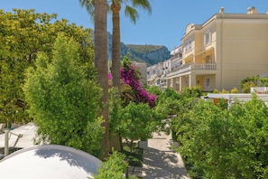 Zona residencial con un sendero, palmeras y un edificio con balcones.