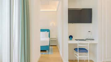 Un dormitorio moderno con cama, escritorio y televisión.