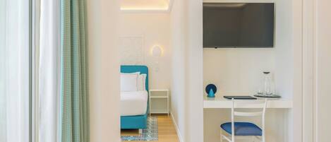 Un dormitorio moderno con cama, escritorio y televisión.