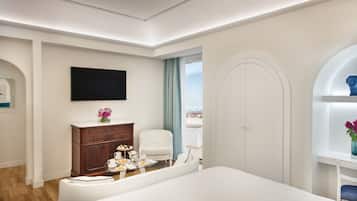 Relax in a spacious room with a large bed, flat-screen TV, and comfortable seating area.