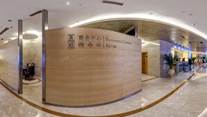 A spacious lobby with a red sofa, a wooden reception desk, and a glass coffee table. - The Pavilion Century Tower Hotel (Shenzhen)