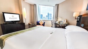 A hotel room with a large bed, a desk with a chair, a television, and a city view. - The Pavilion Century Tower Hotel (Shenzhen)