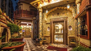 An ornate entrance with intricate designs, a reception area, and a tiled floor.