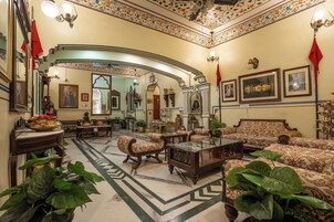 Uma sala de estar ampla com mobiliário requintado, um espelho grande e obras de arte decorativas nas paredes.