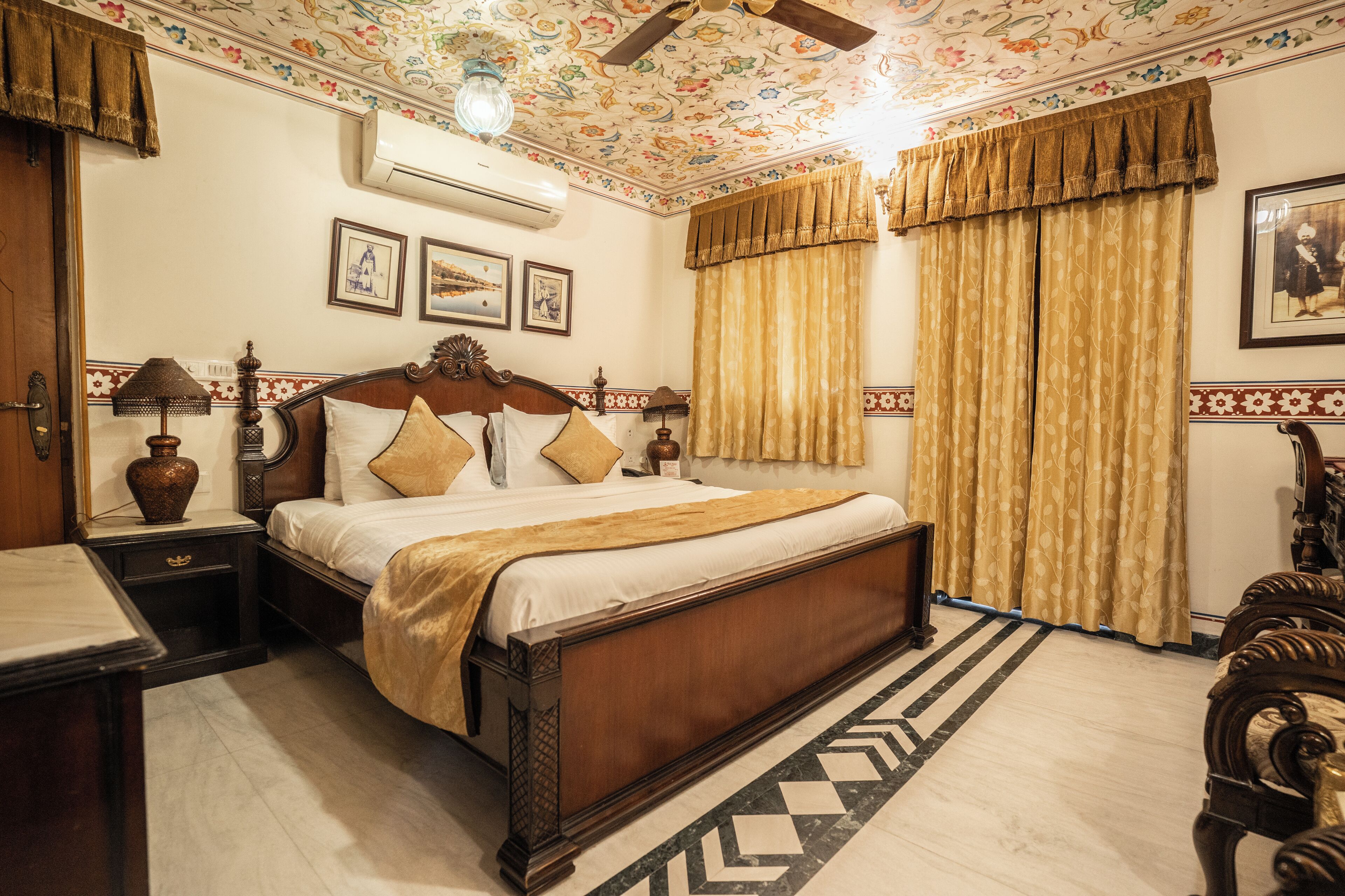 A traditional bedroom with a wooden bed, a nightstand, a lamp, and a ceiling fan.