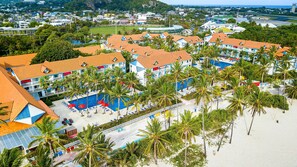 A resort with multiple buildings, a swimming pool, and a beach area.