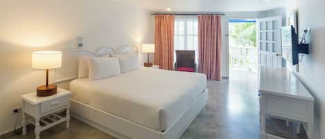 A hotel room with a large bed, bedside lamps, a television, and a view of the outdoors.