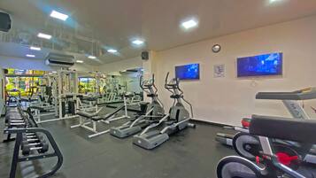 Ein Fitnessstudio mit verschiedenen Trainingsgeräten, darunter Laufbänder und Kraftgeräte.