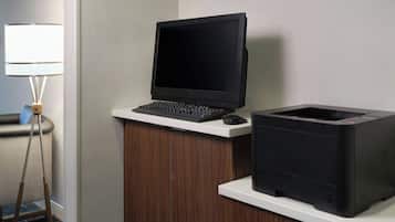 A desk with a laptop, a printer, and a lamp.