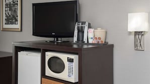 Une kitchenette équipée d’un four à micro-ondes, d’une machine à café et d’un téléviseur à écran plat.