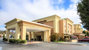 A hotel with a covered entrance, a sign reading "Hampton Inn," and a parking lot. - Hampton Inn Lewisburg (Lewisburg)