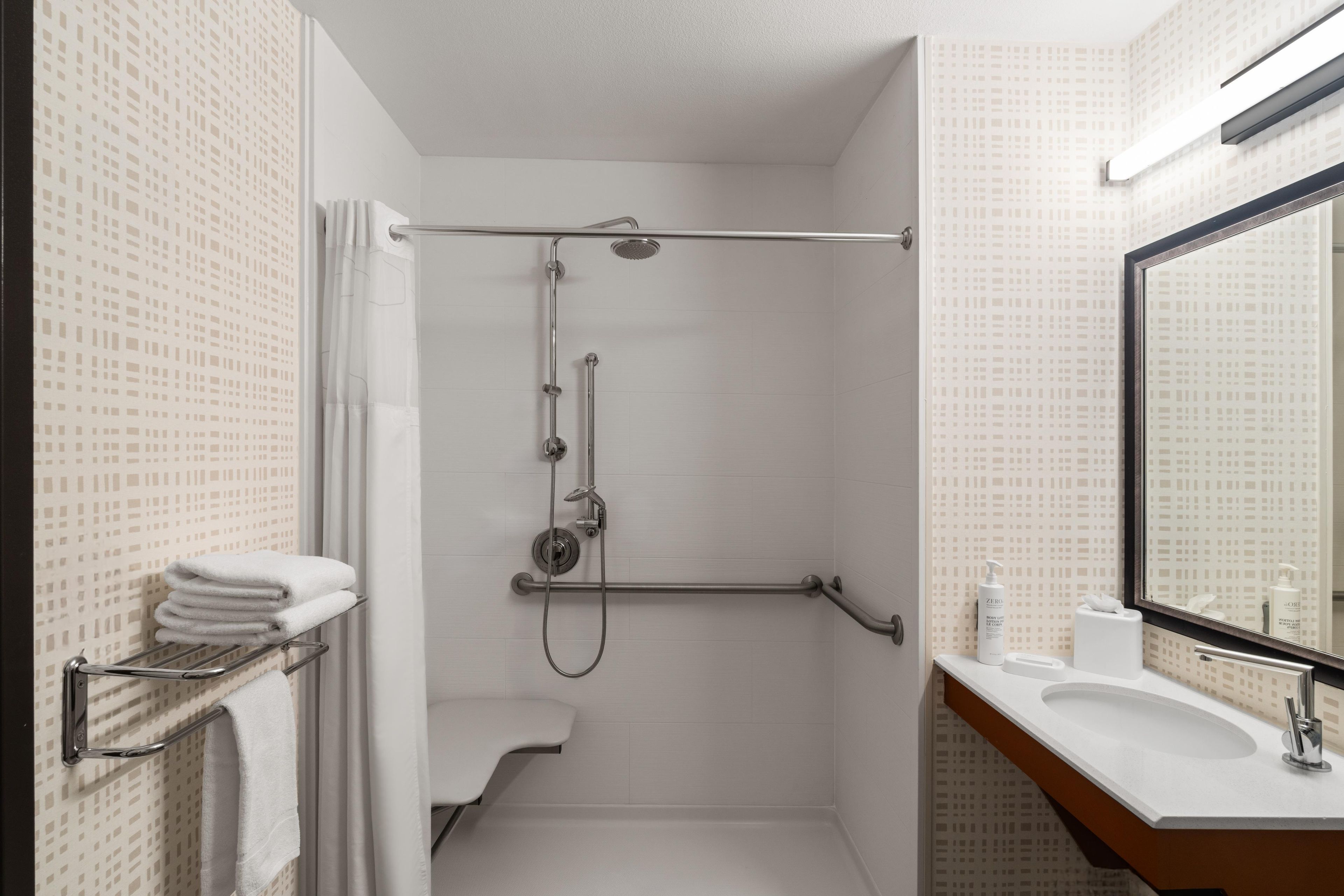 A bathroom with a shower, toilet, and sink.