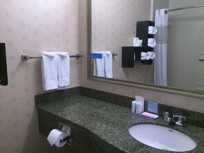 A bathroom with a granite countertop, a white sink, a towel rack with white towels, a mirror, and a shower curtain. - Hampton Inn & Suites Mountain View (Mountain View)