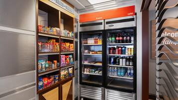 Un área de venta automática con aperitivos y bebidas variadas.