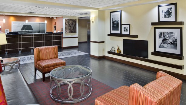 Eine Lobby mit Empfangstresen, Sitzgelegenheiten und Wandbildern.