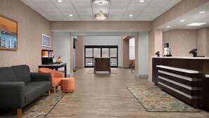 A hotel lobby with a reception desk, a sofa, and a coffee station.