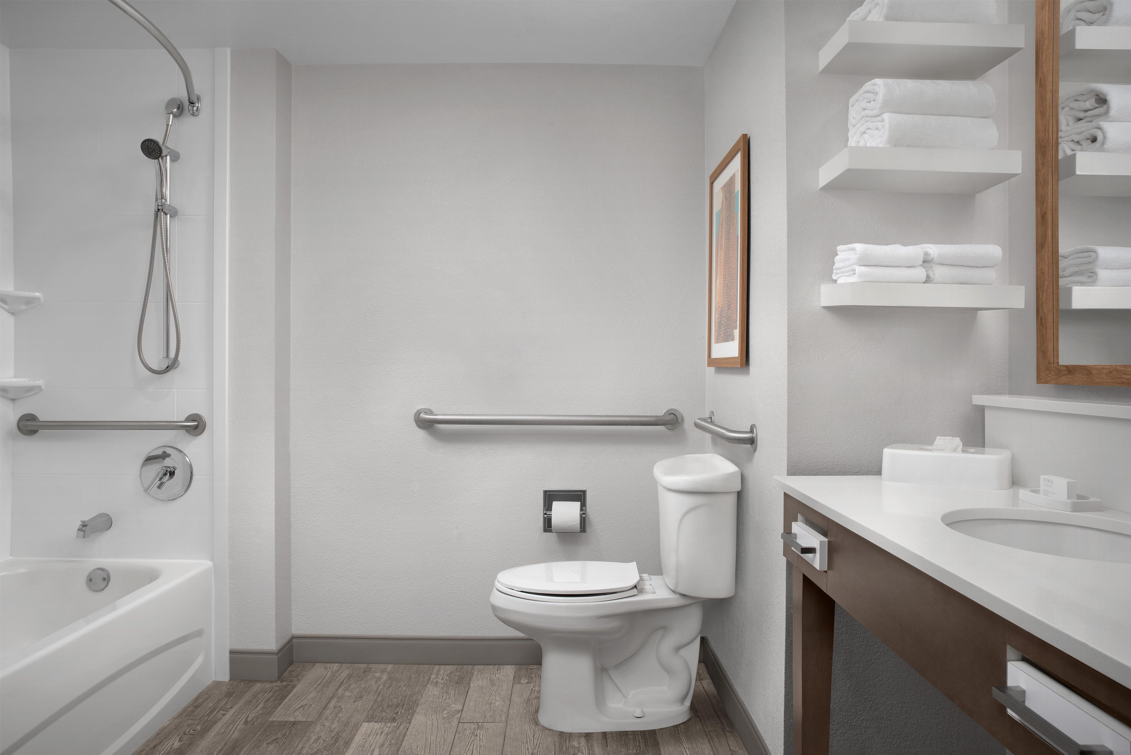 A modern bathroom with a bathtub, toilet, and shower.