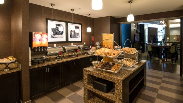 Zona de buffet amb diversos plats, una estació de cafè i una zona de seients al fons.