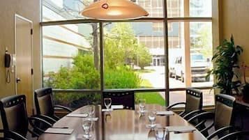 A conference room with a large table, chairs, and a hanging light fixture.