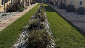A row of townhouses with a central lawn and a clear sky. - Clinton Inn And Suites (Port Clinton)