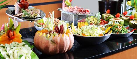 A buffet with various dishes and garnishes.