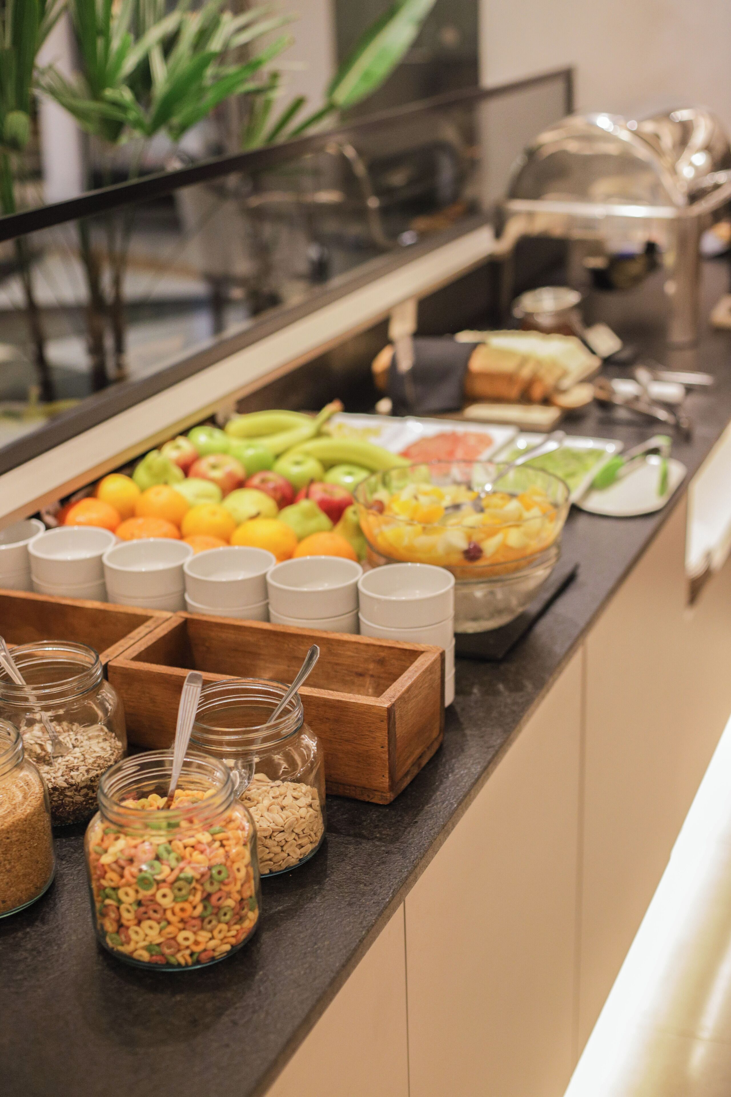 A buffet counter with various food items and containers.