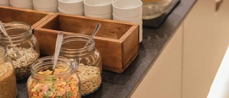 A buffet counter with various food items and containers.