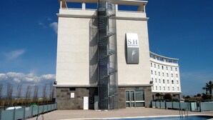 Een hotel met een modern ontwerp, een centraal gelegen trap en een zwembad.