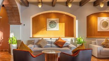A modern interior with a sofa, chairs, a round table, and decorative wall art.