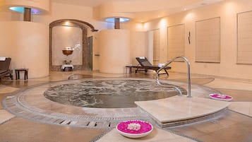 Relax in the serene spa area with a central hot tub and lounge chairs.