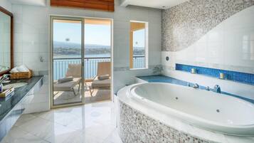 Un baño moderno con una bañera grande, un balcón con asientos y vistas a un lago.