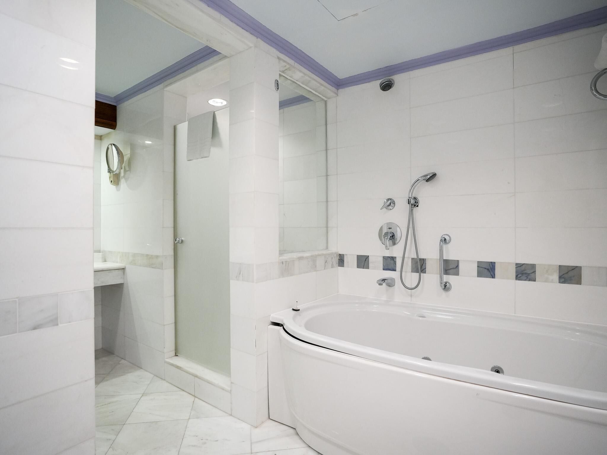 A modern bathroom with a glass shower enclosure, a bathtub, and a vanity with a mirror.