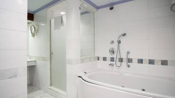 A modern bathroom with a glass shower enclosure, a bathtub, and a vanity with a mirror.