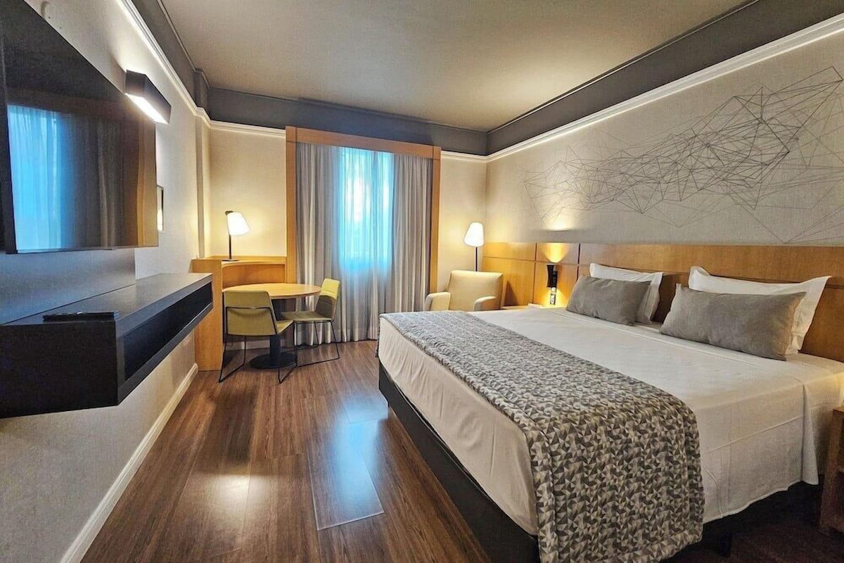 Une chambre d’hôtel comprenant un lit, des tables de chevet, un bureau et une chaise.