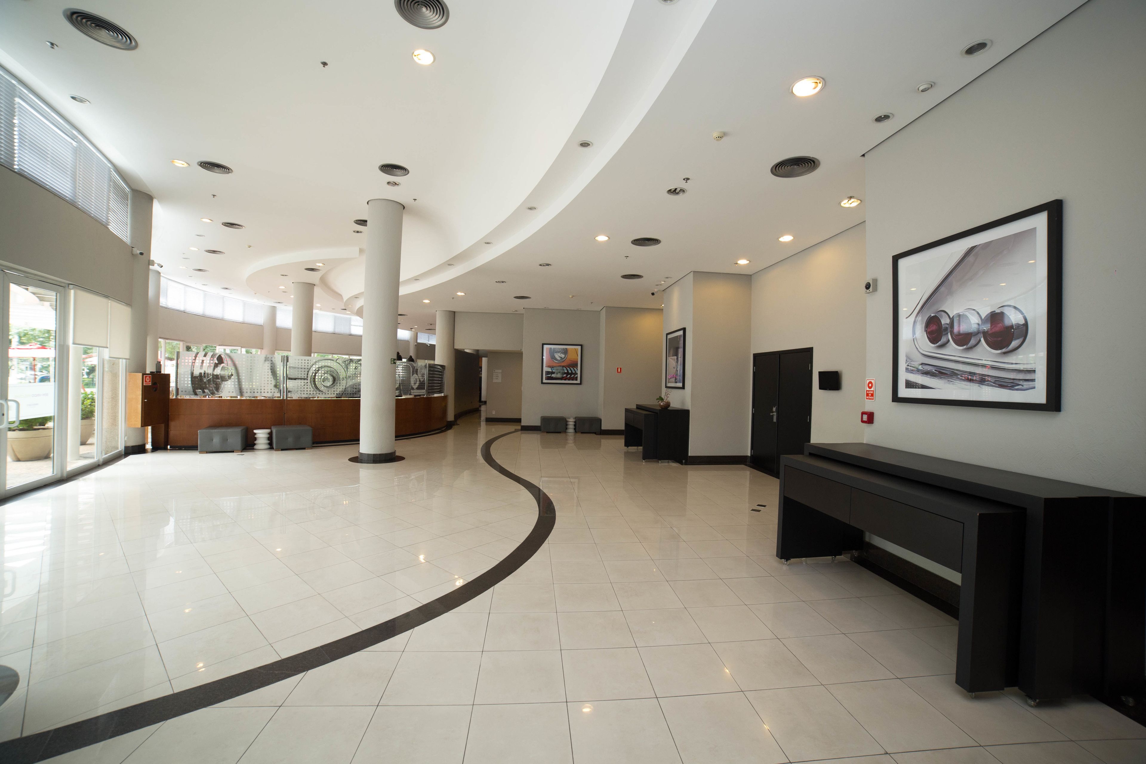A spacious lobby with a curved ceiling, a reception desk, and a bench along the wall.