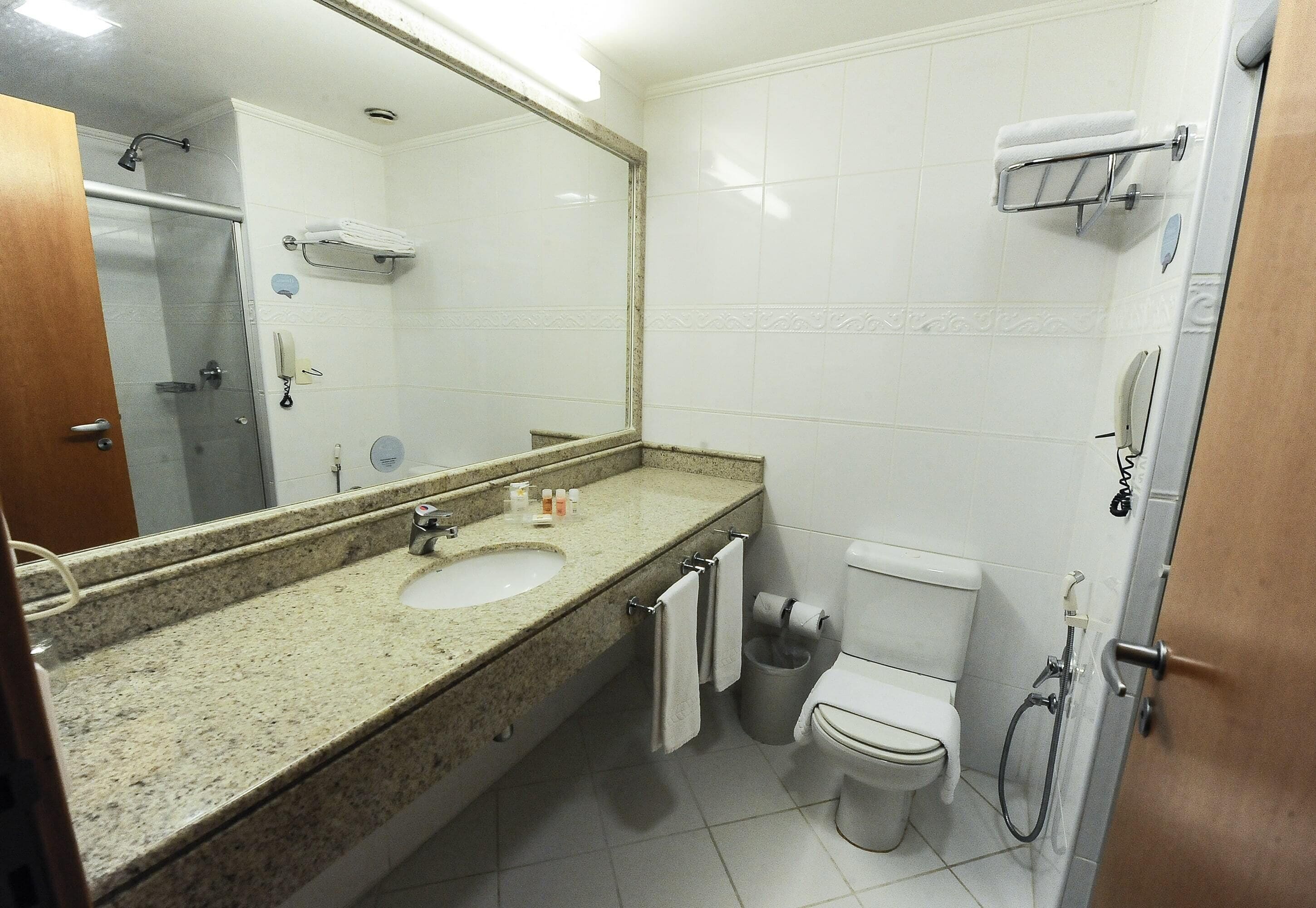 Une salle de bain équipée d’un lavabo, d’un miroir, de toilettes et d’une douche.