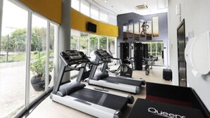 A gym with treadmills, exercise bikes, and weight machines.