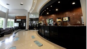 A modern reception area with a curved reception desk, large windows, and a clean, tiled floor.