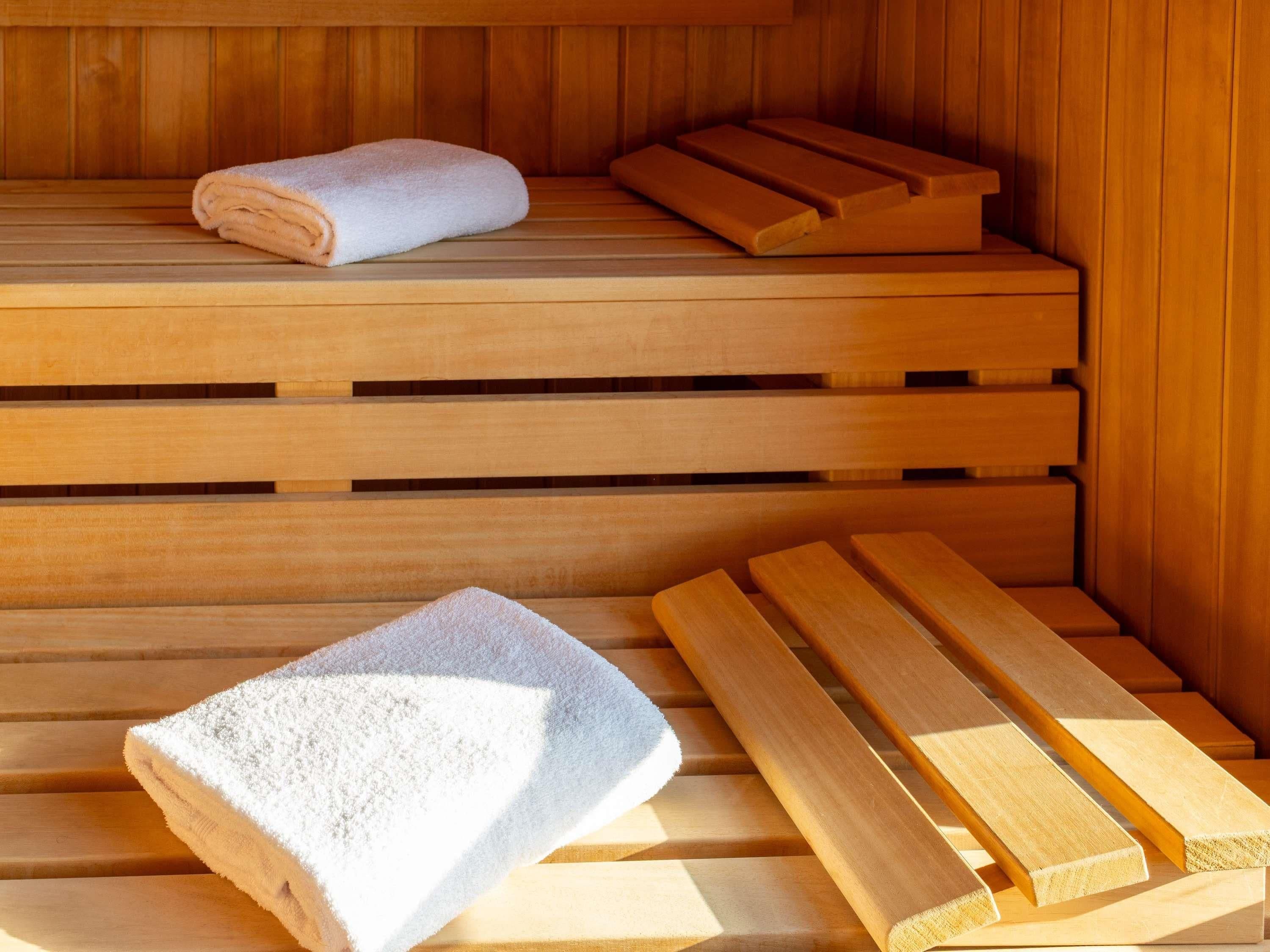 A sauna with wooden benches and a towel.
