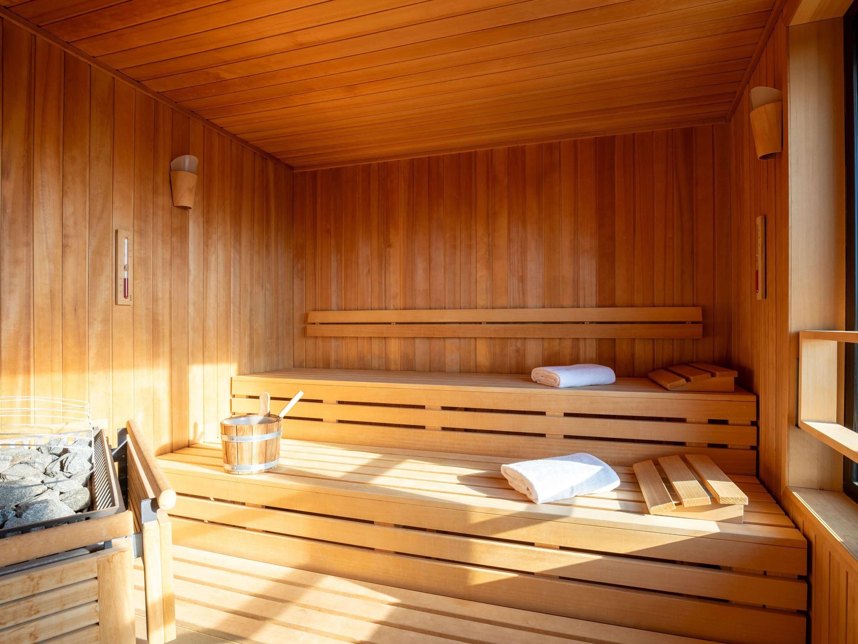 Sauna, jossa on puiset lauteet, pyyhe ja ämpäri.