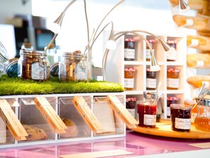 Une vitrine de boulangerie avec des pots de confiture et du pain.