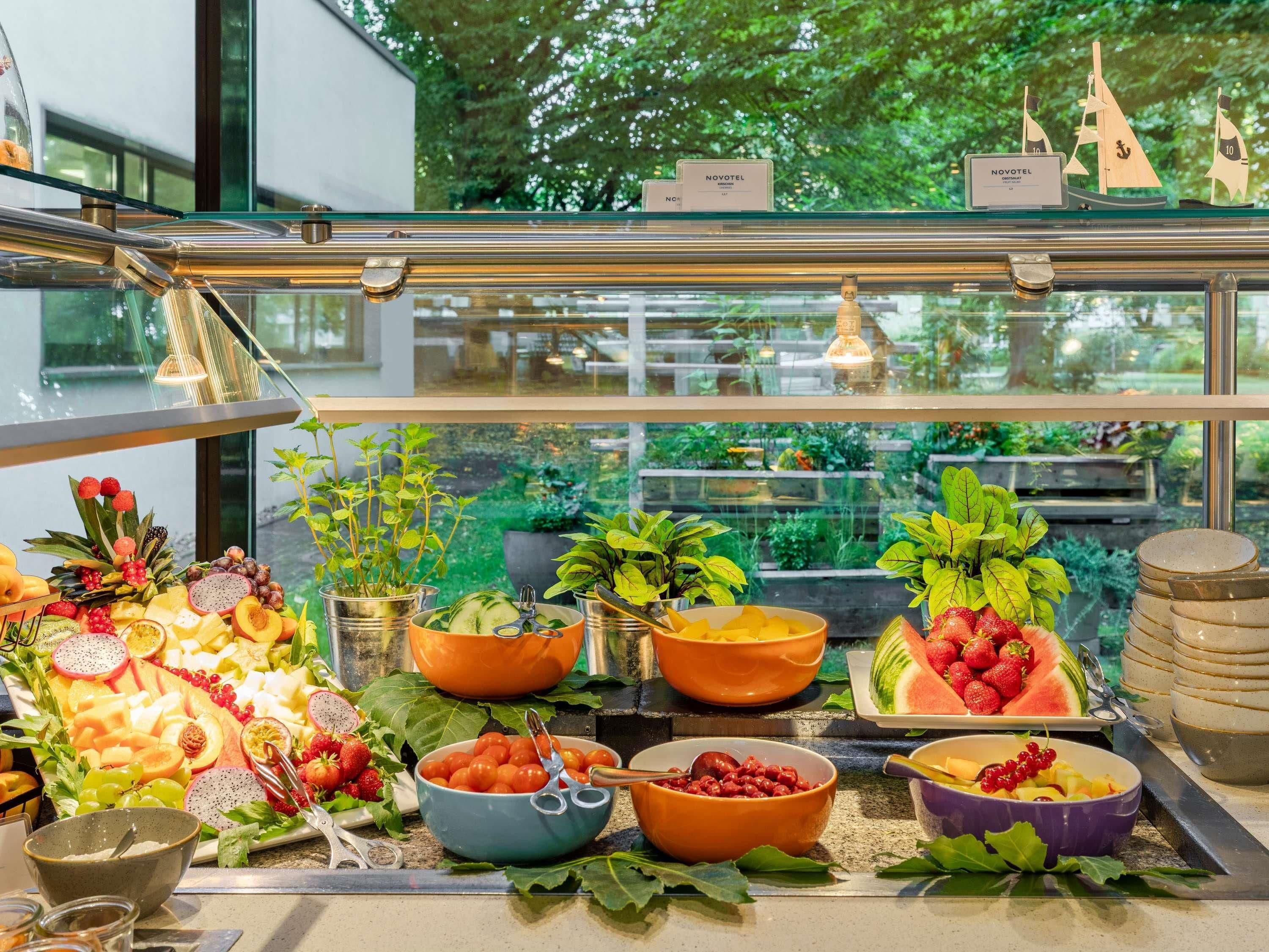 Un buffet proposant une variété de fruits, de légumes et de fromages, avec une vue sur la verdure environnante.